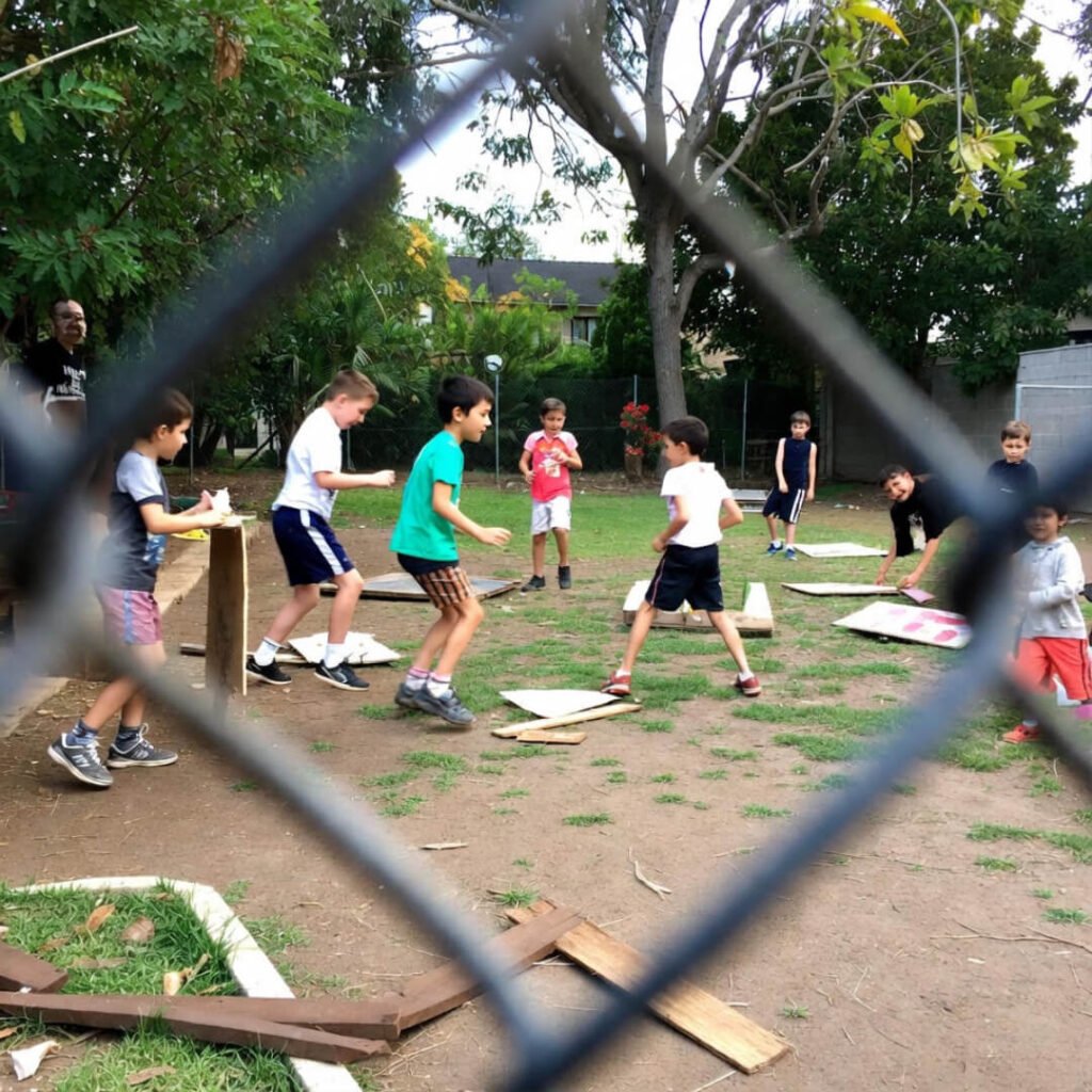 Smirking reflection with card in holiday-lit window.